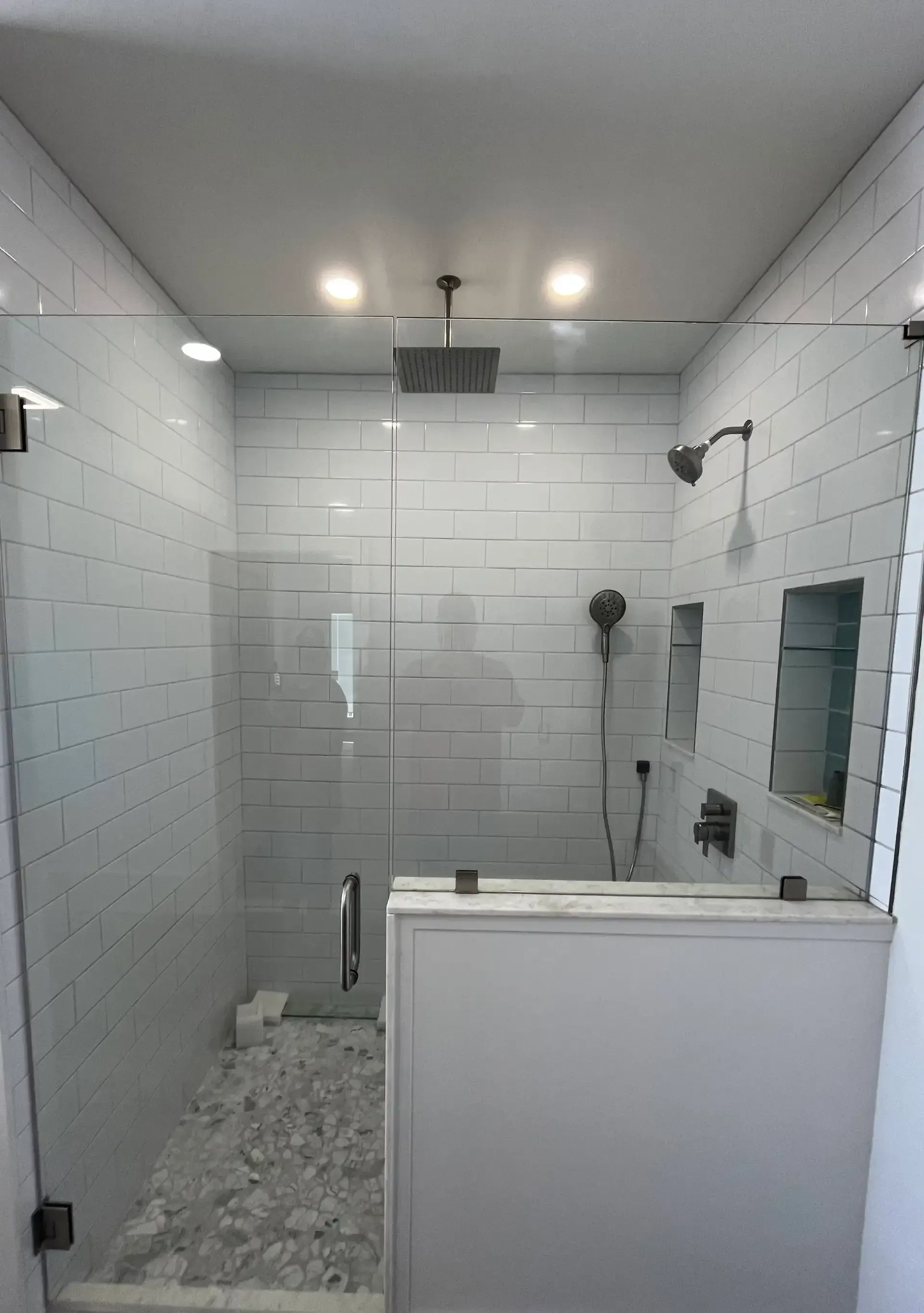 White subway tile shower with glass enclosure and niche