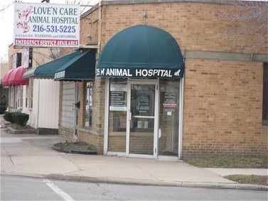 Love'N Care Animal Hospital: brick building with green awning over entrance; sign with phone number.