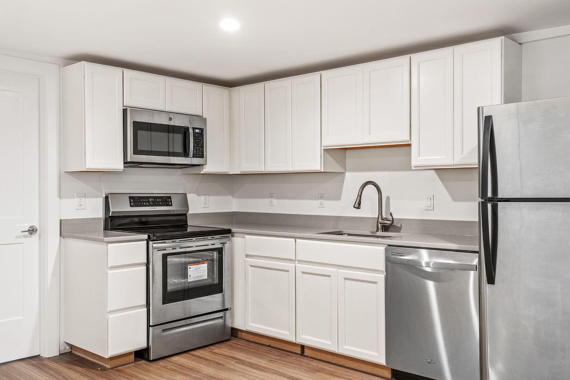 Basement kitchen remodel with white cabinets and stainless steel appliances