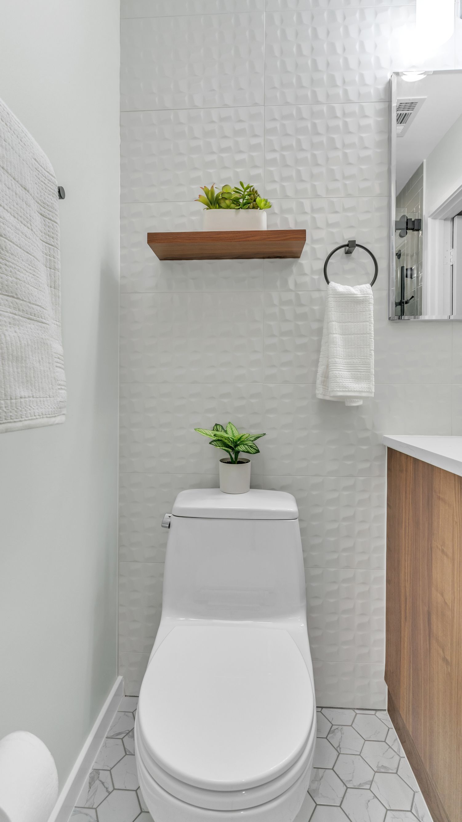 modern bathroom remodel with white 3d tile, floating wood shelf, and minimalist toilet