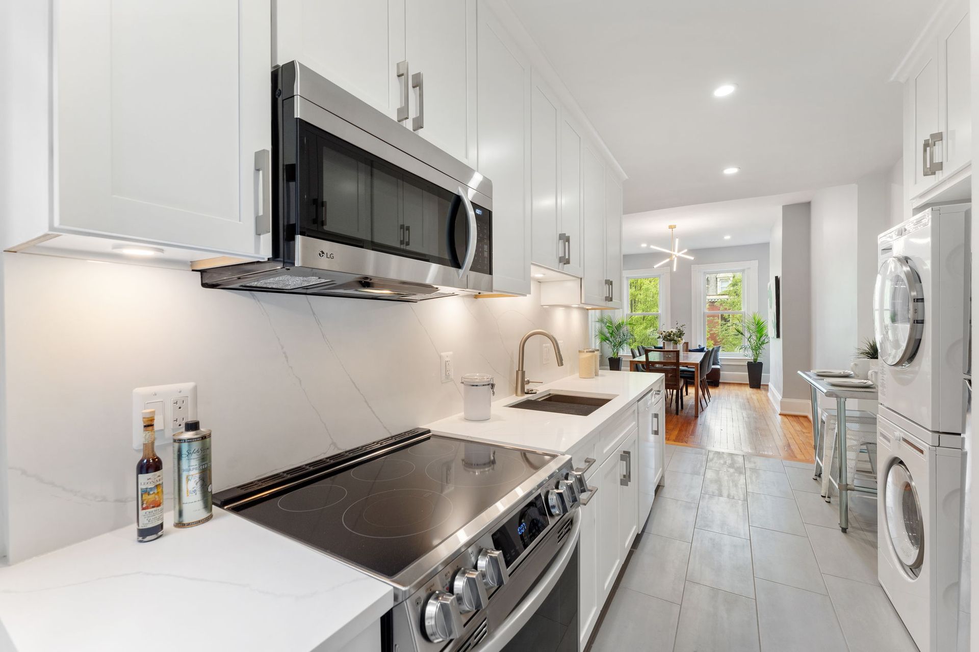modern kitchen island built-in banquette globe pendant lights white cabinets open shelving