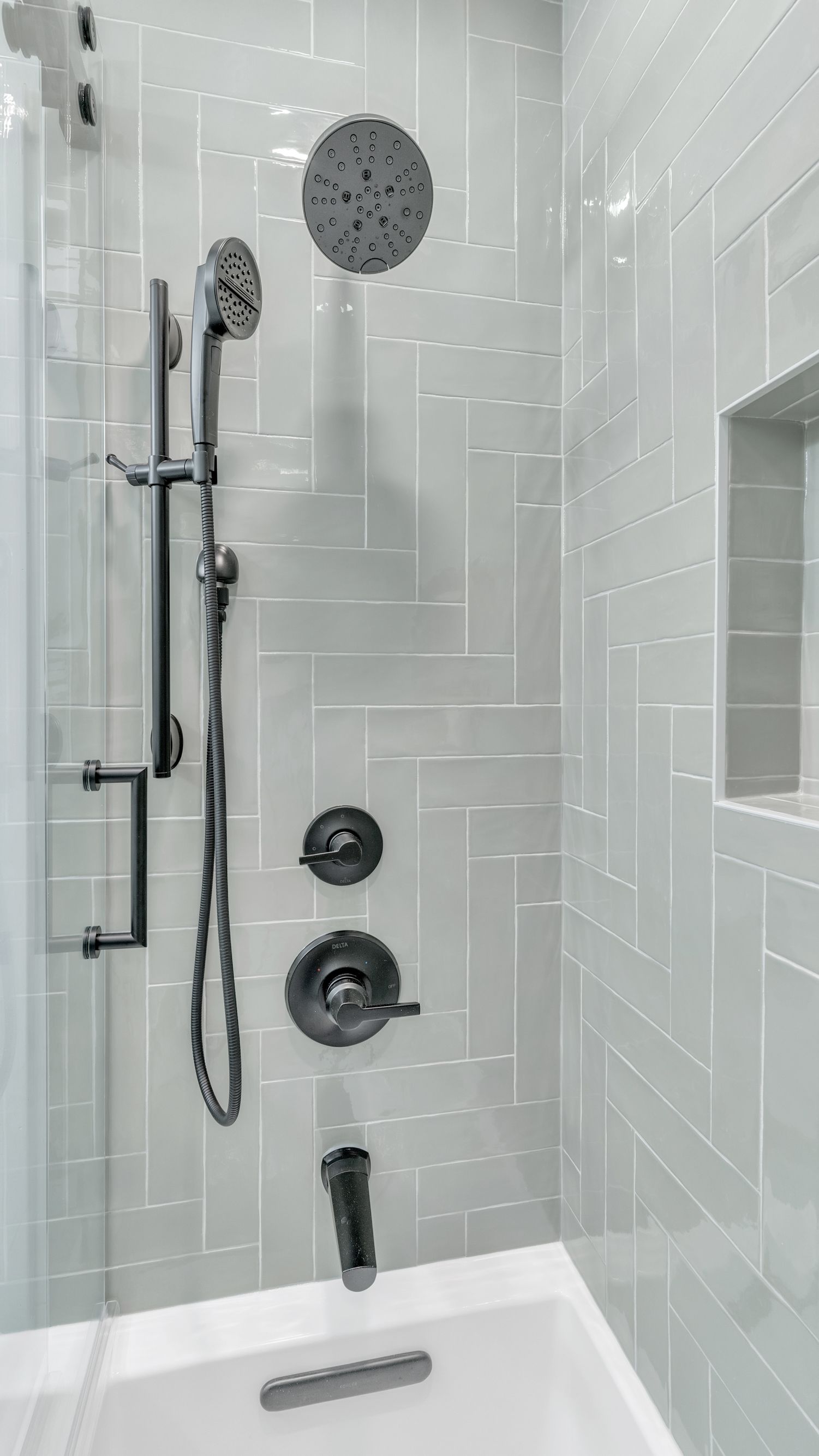 glossy gray shower tile with black showerhead and fixtures in bathroom remodel Washington DC historic homes