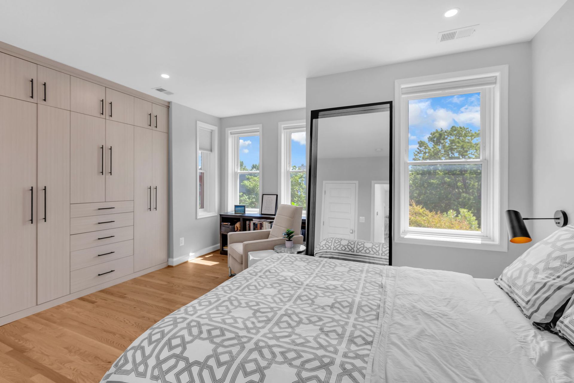 bright modern bedroom with built-in wardrobe, reading nook, and large windows in Washington DC historic home remodel