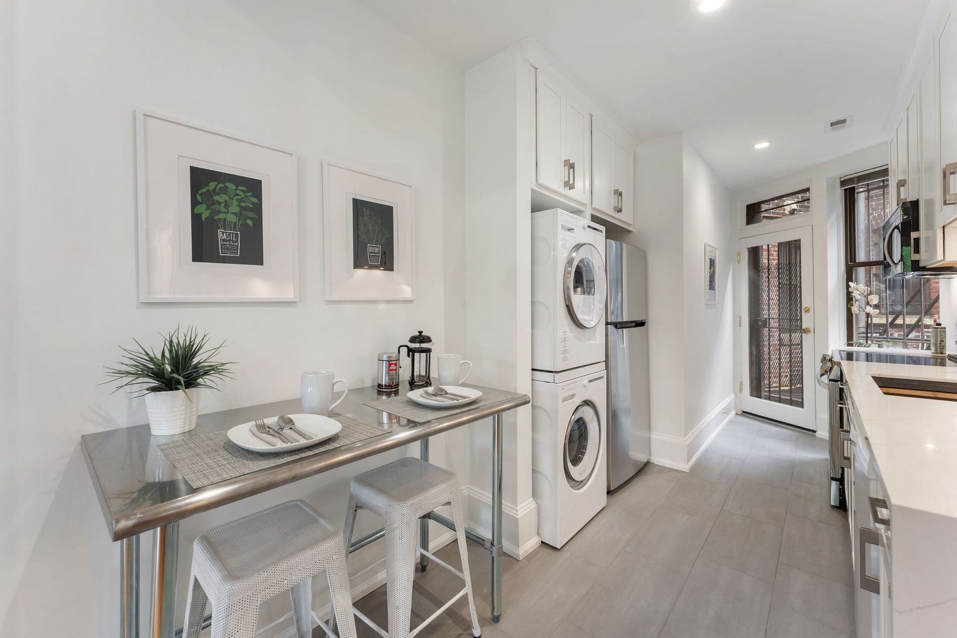 compact kitchen with breakfast nook and stacked laundry near glass door