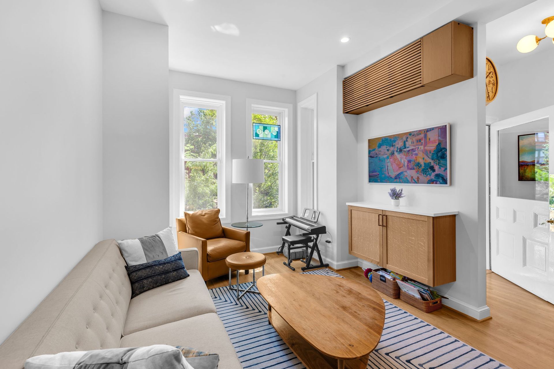 small living room remodel with built-in cabinet, colorful art, stained glass, and music corner in Washington DC rowhouse