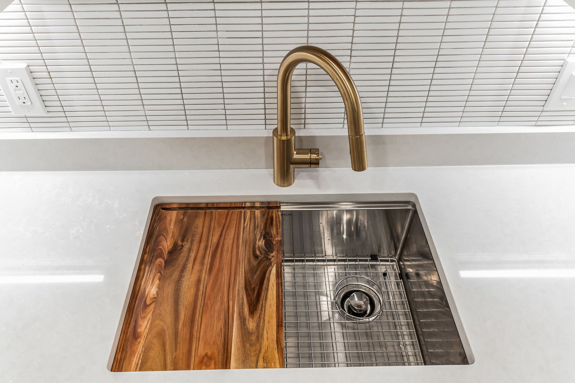 gold kitchen faucet with white quartz countertop, modern backsplash, and stainless steel sink for home remodeling in washington dc
