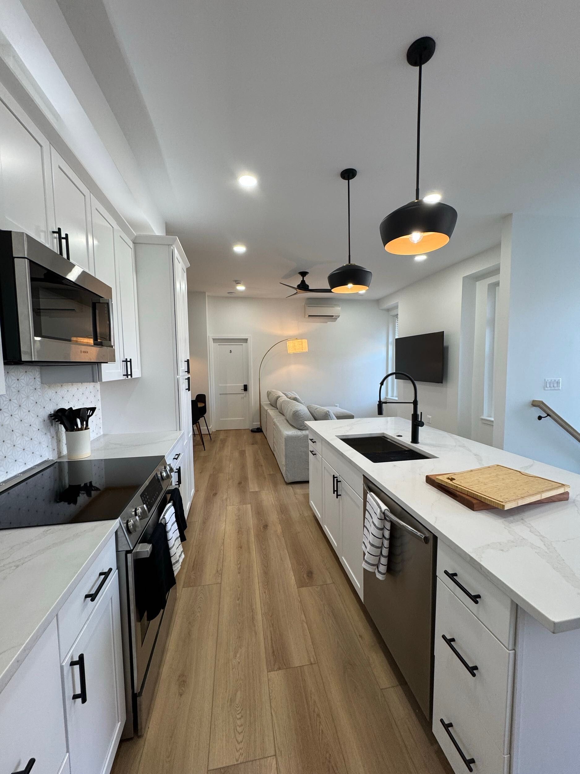 white kitchen open floor plan quartz countertops modern lighting black hardware DC home renovation