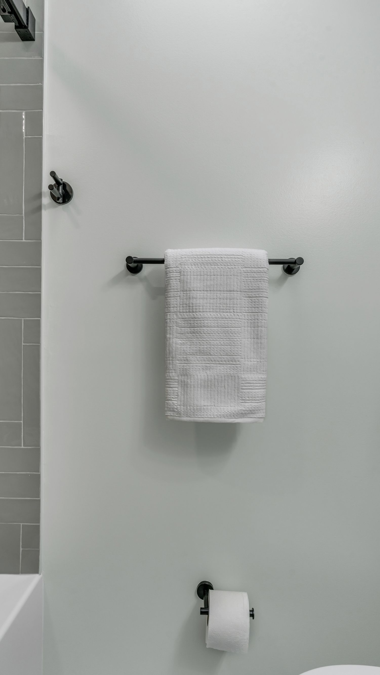 modern bathroom remodel with black towel bars and white tile accent wall, Washington DC historic home renovation