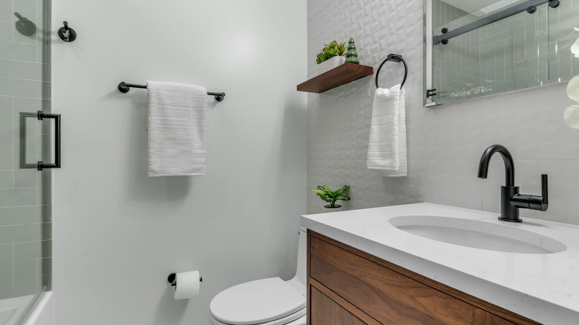 modern bathroom remodel with floating vanity black fixtures white quartz countertop and wall-mounted towel bars