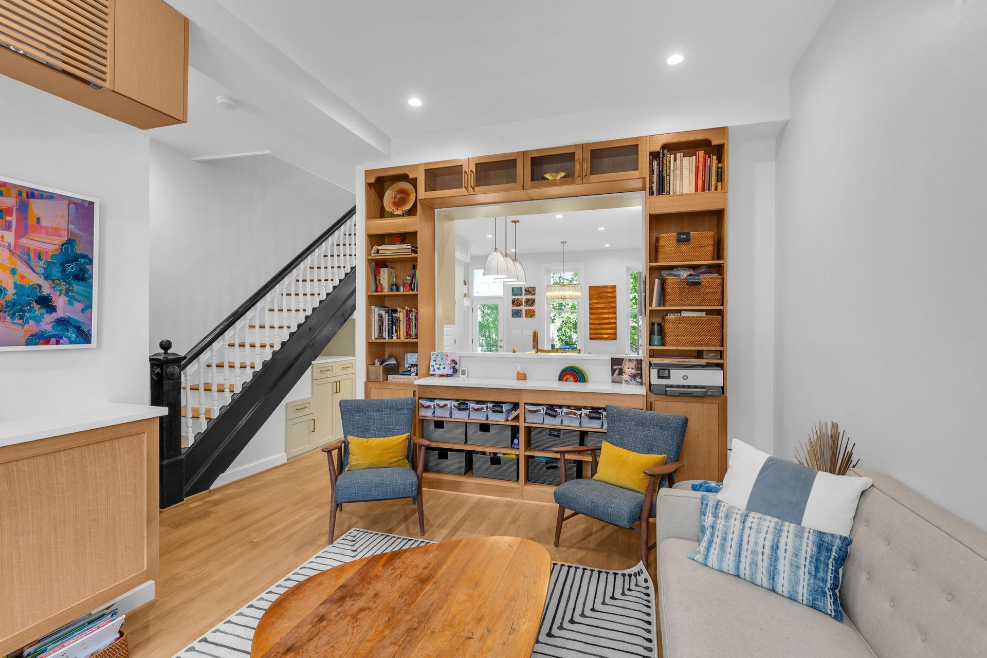 modern family room remodel with built-in storage, custom millwork, and open sightline to kitchen in Washington DC rowhouse