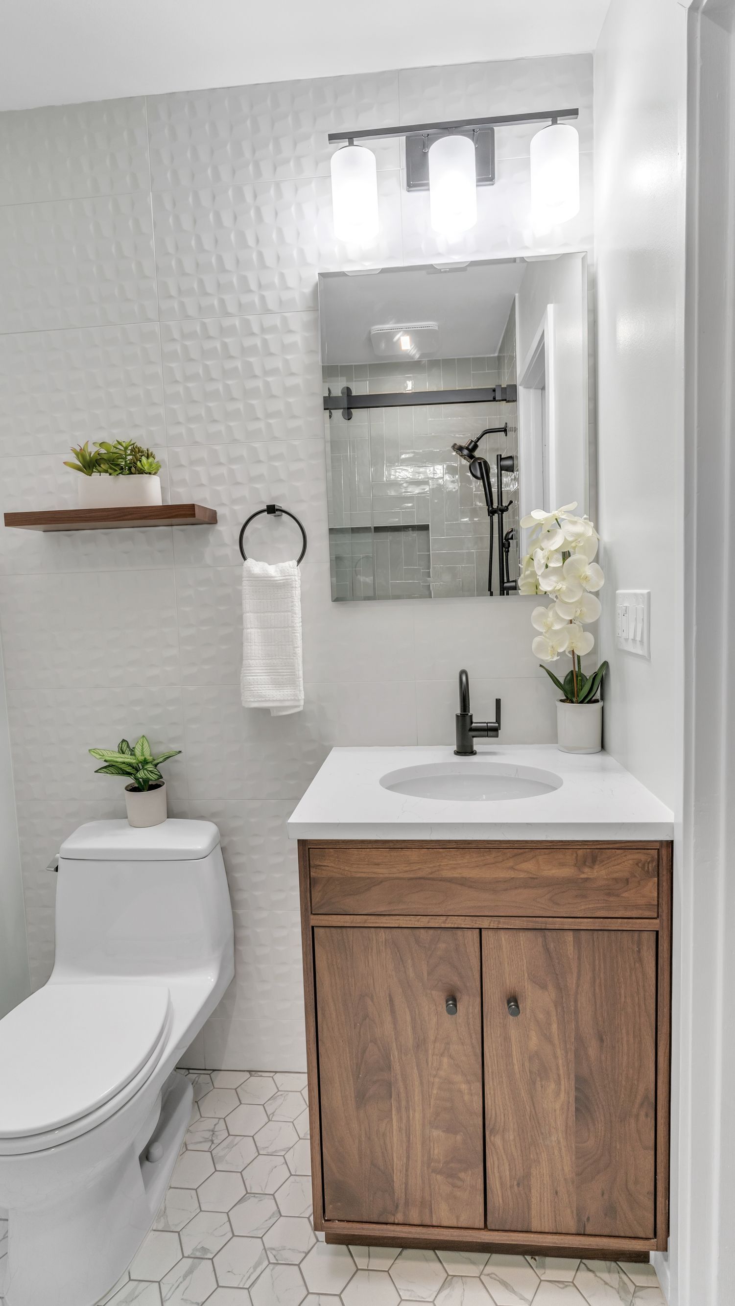 modern bathroom vanity wood cabinet black faucet white countertop textured wall