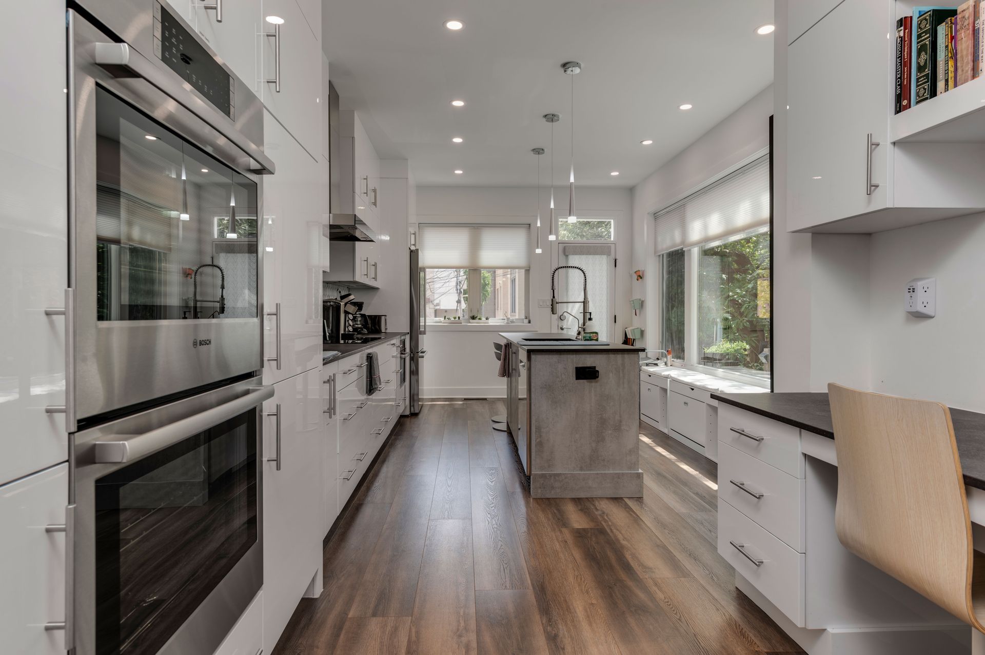 Contemporary kitchen with island, built-in desk, and stainless steel double ovens