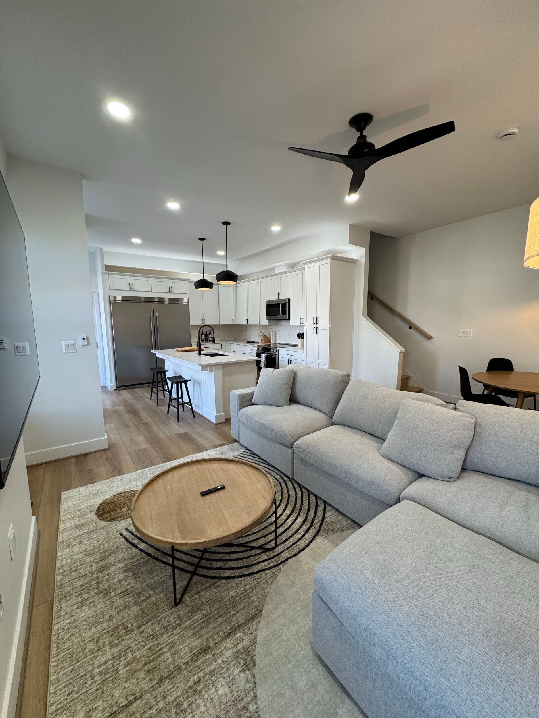 modern open living room kitchen layout with light wood floors, white cabinets, black hardware, DC home renovation