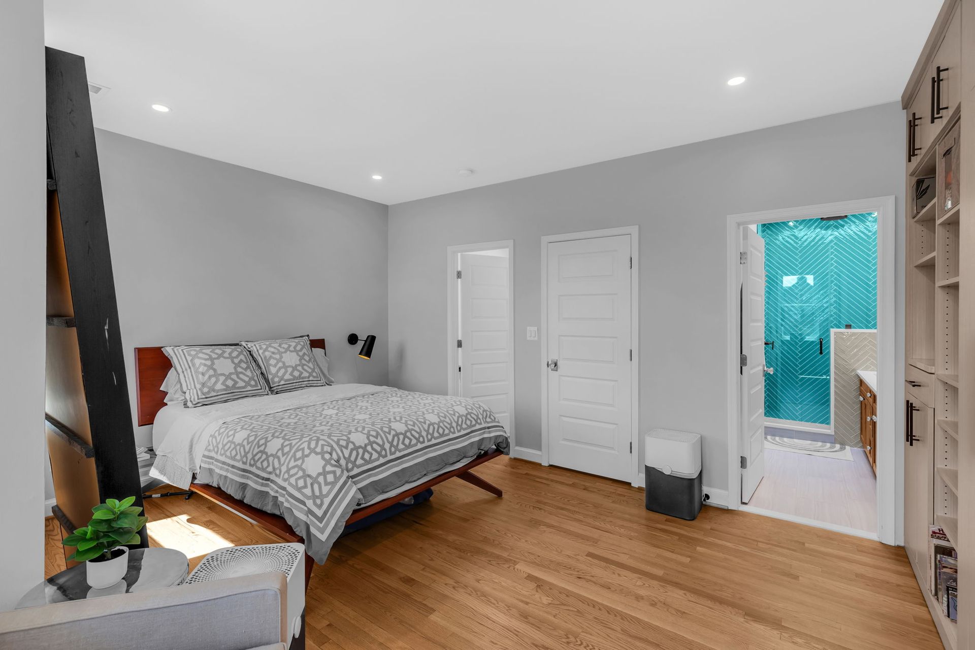 modern primary bedroom with ensuite bathroom, built-ins, blue tile shower, and gray walls in Washington DC historic home renovation