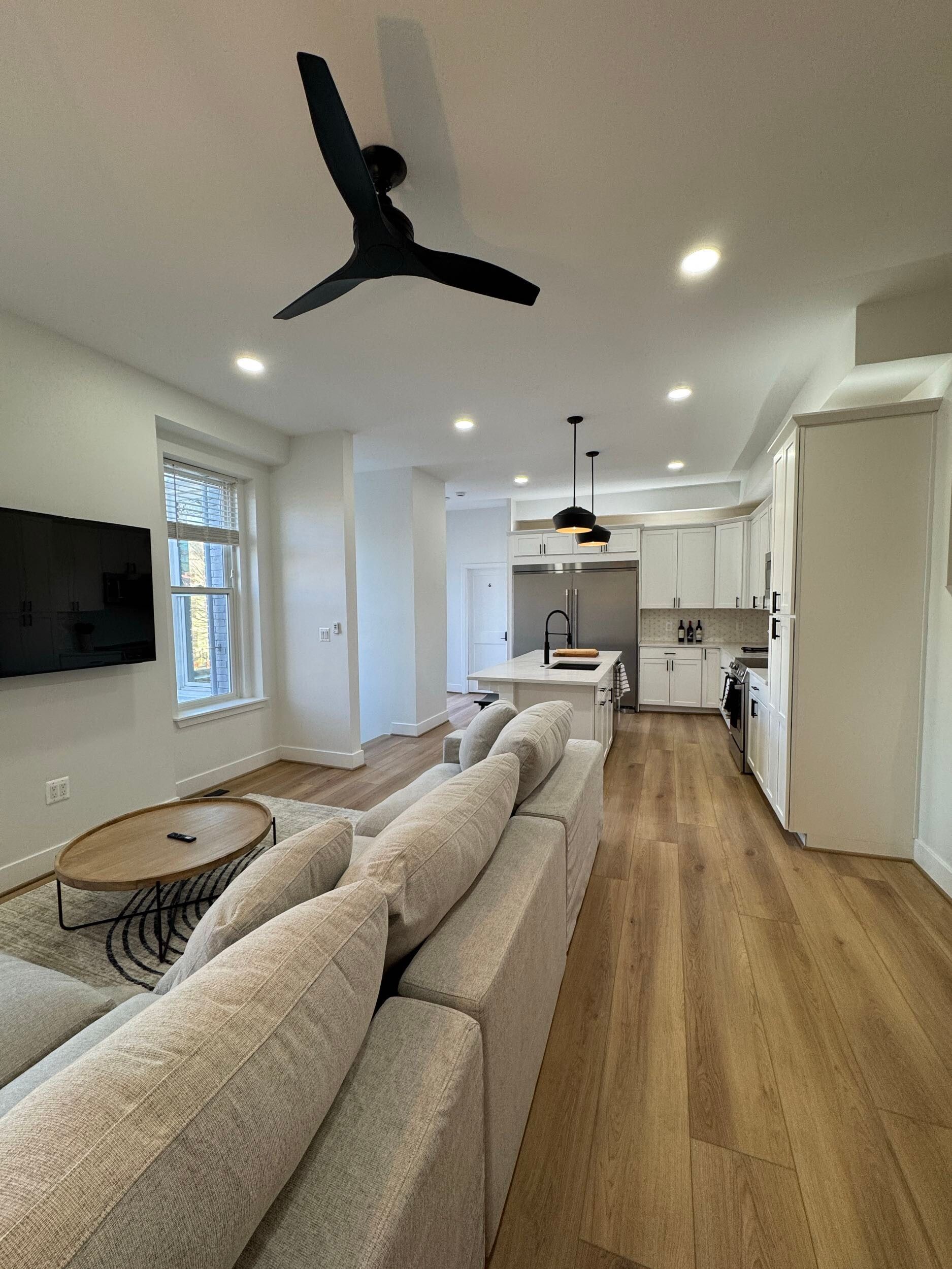 open concept living room kitchen remodel with white cabinets, black fixtures, light wood floors, Washington DC