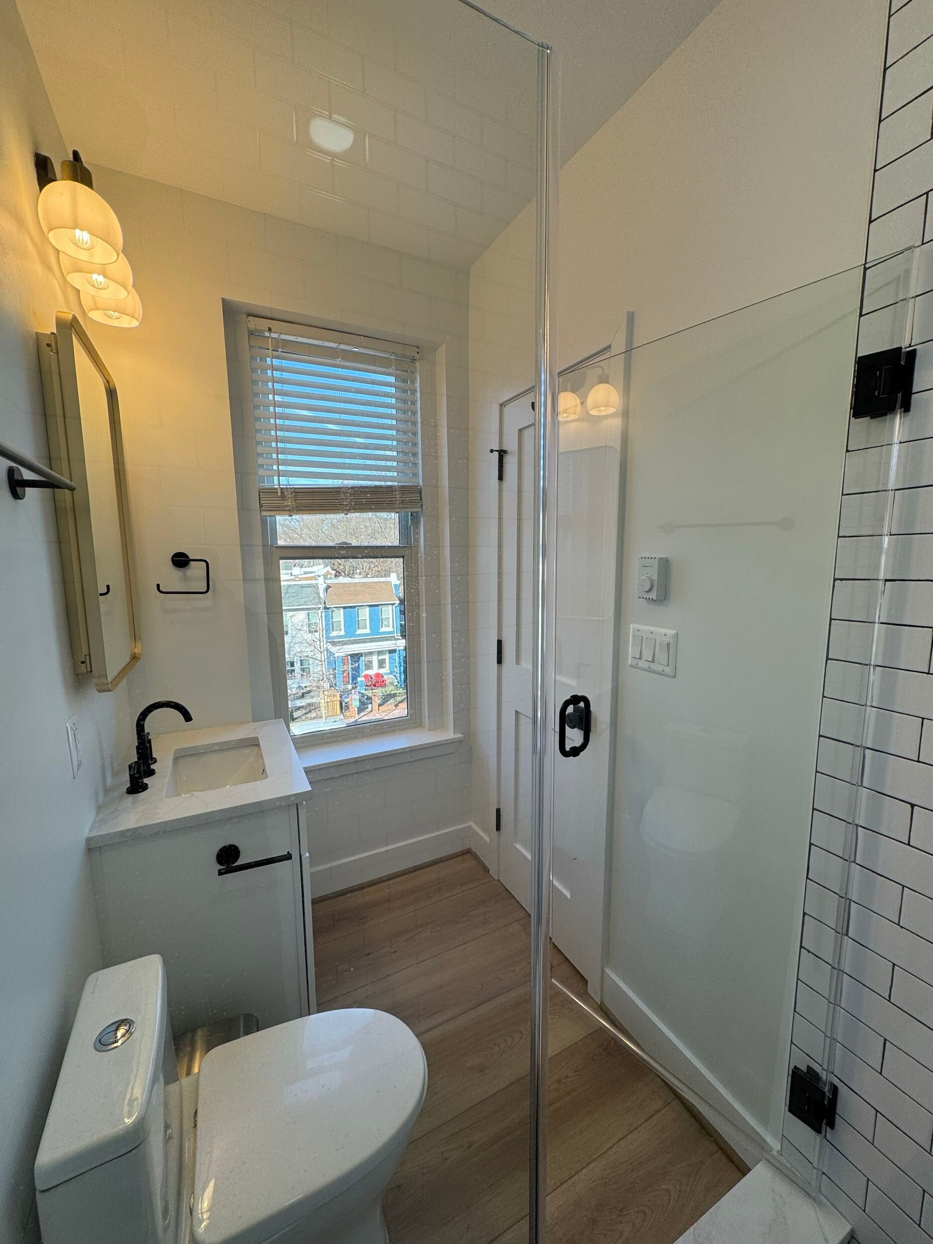 small bathroom remodel glass shower white vanity black fixtures natural light