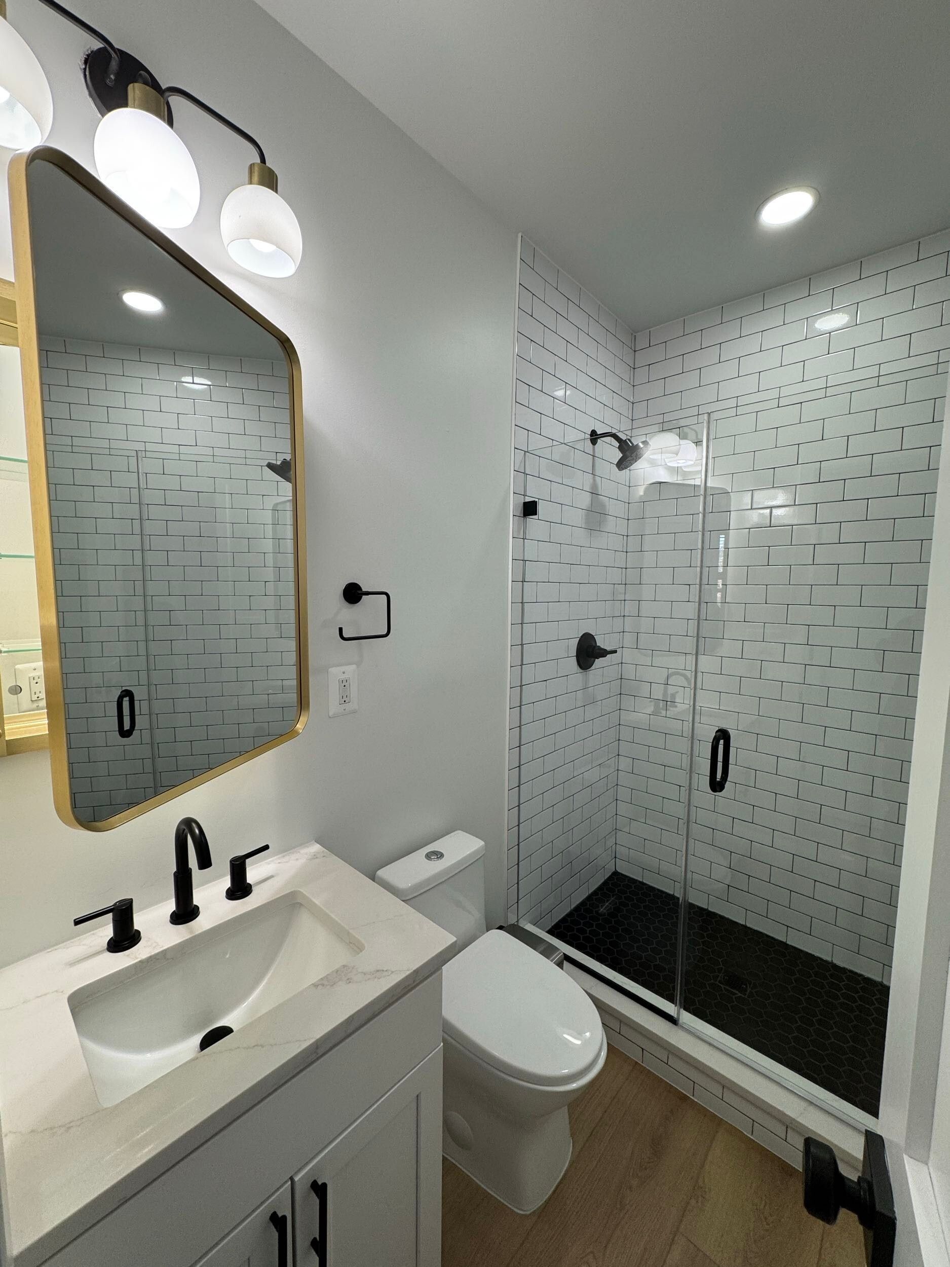 small bathroom remodel white vanity black fixtures glass shower subway tile modern DC renovation