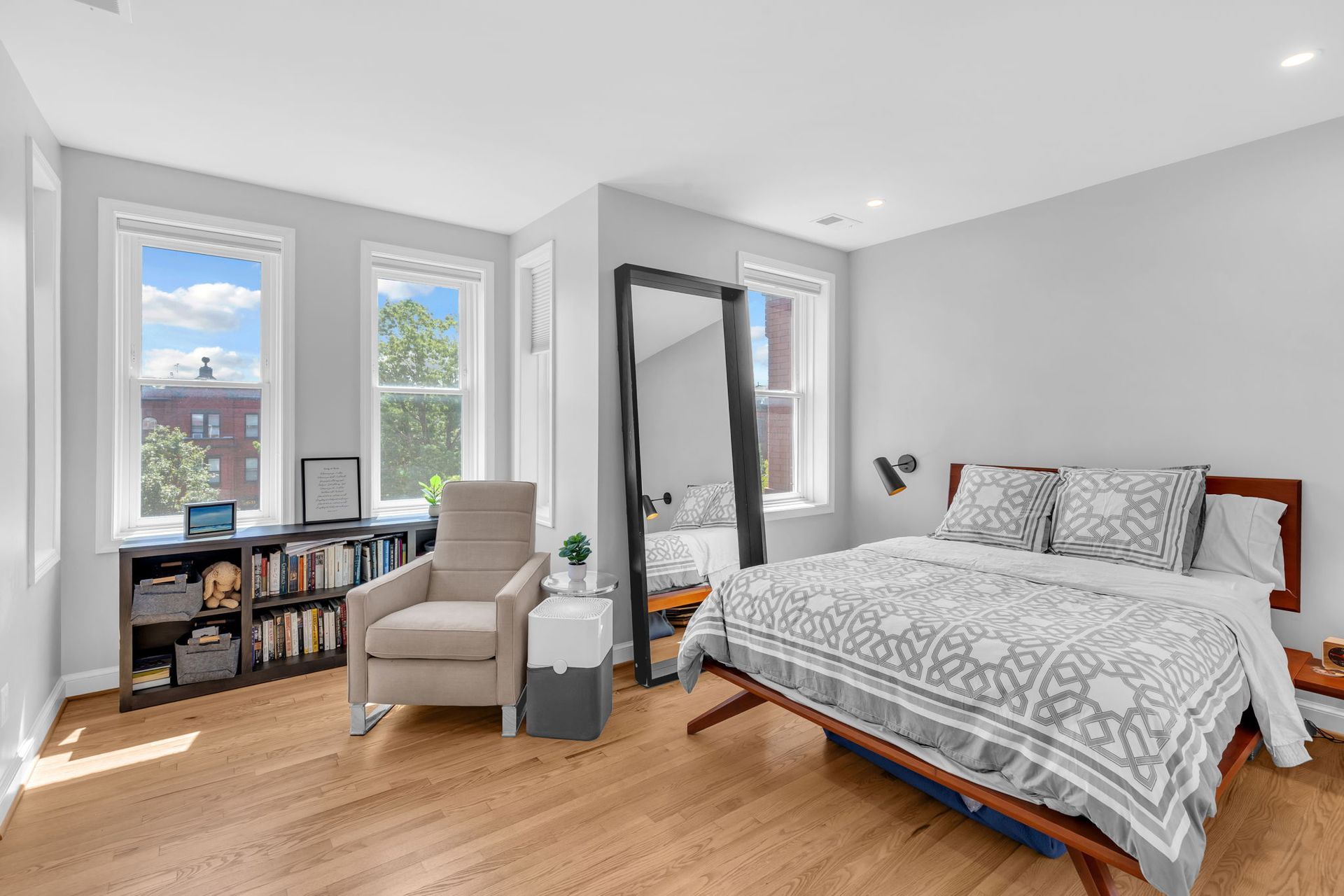 sunlit bedroom with reading nook, modern gray walls, wood floors, and built-in bookcase in Washington DC rowhouse renovation