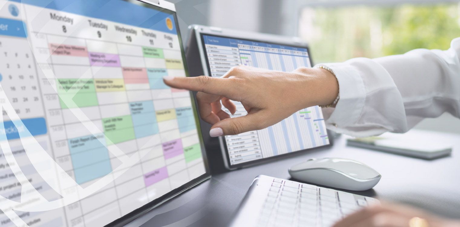 Person points at a digital calendar on a computer screen, likely scheduling or organizing.