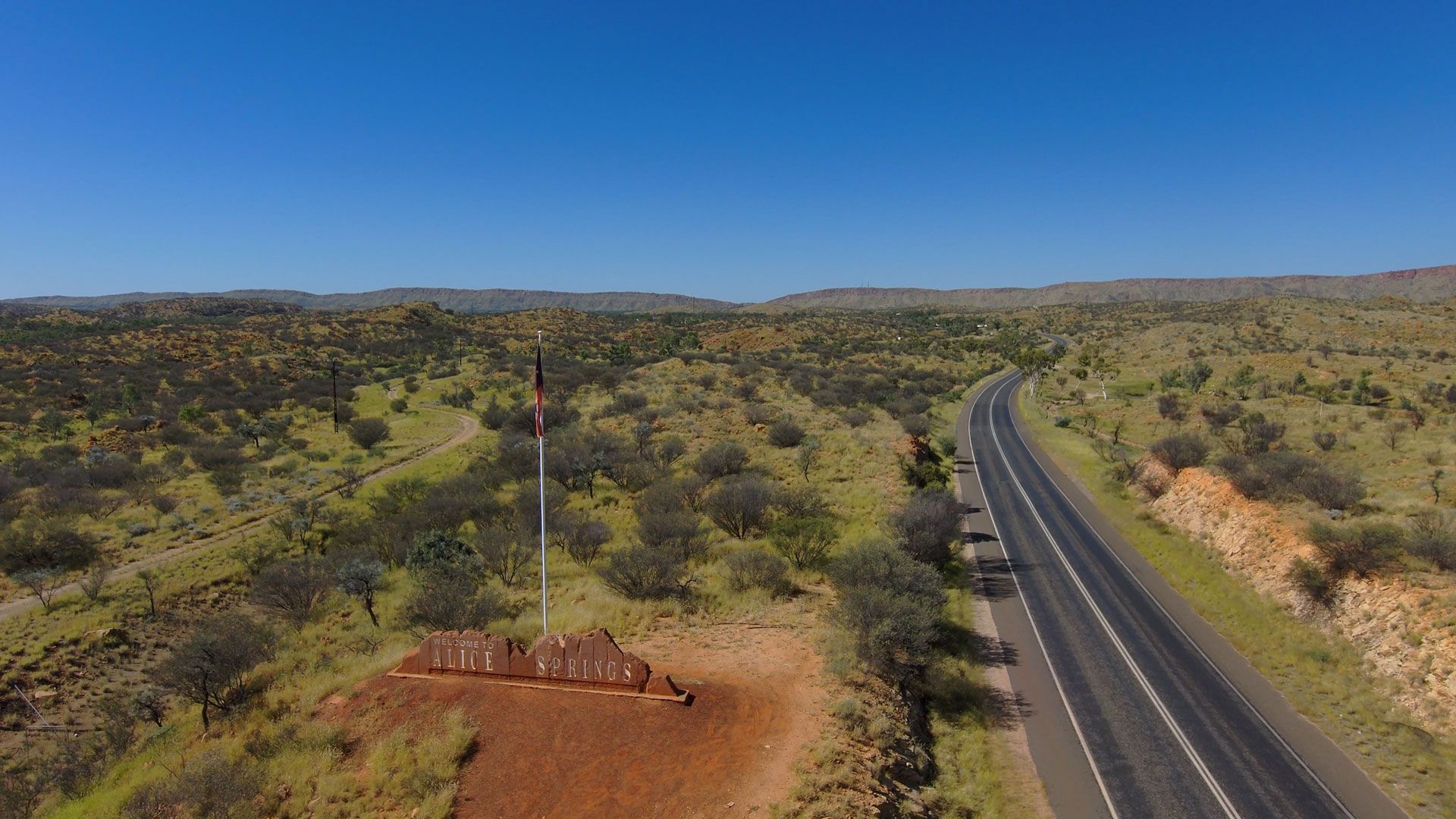 an aerial view of a highway going through a desert landscape .