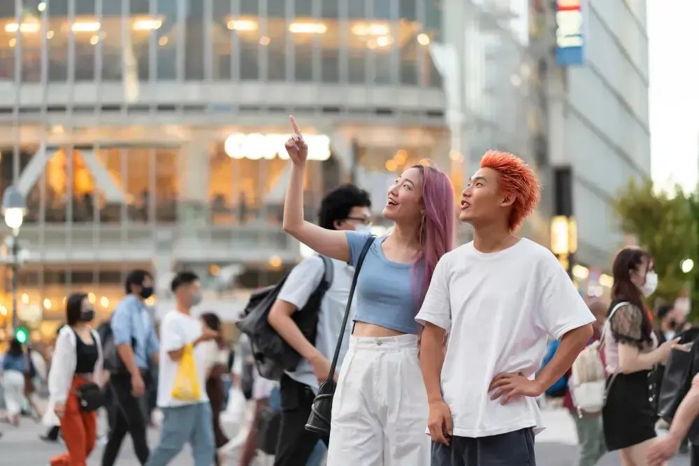A man and a woman are standing on a crowded city street.
