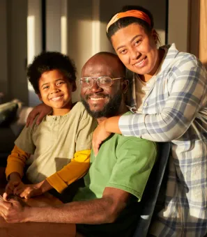 A family is posing for a picture while sitting at a table.