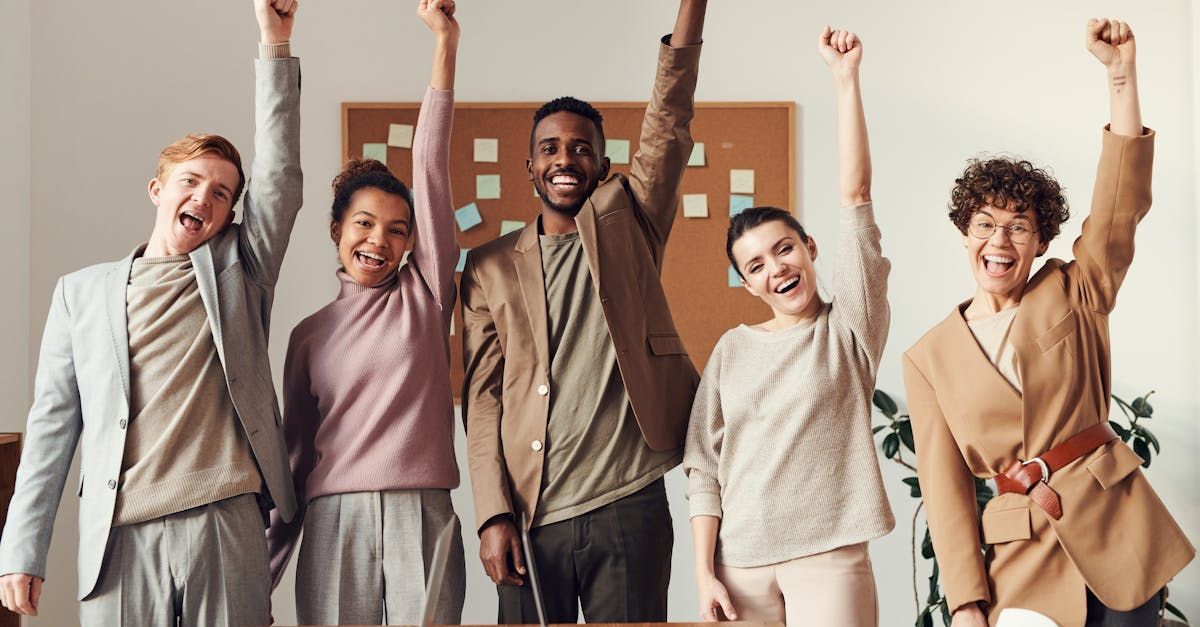 A group of people are standing next to each other with their arms in the air.