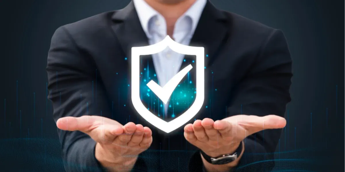 A man in a suit is holding a shield with a check mark on it.