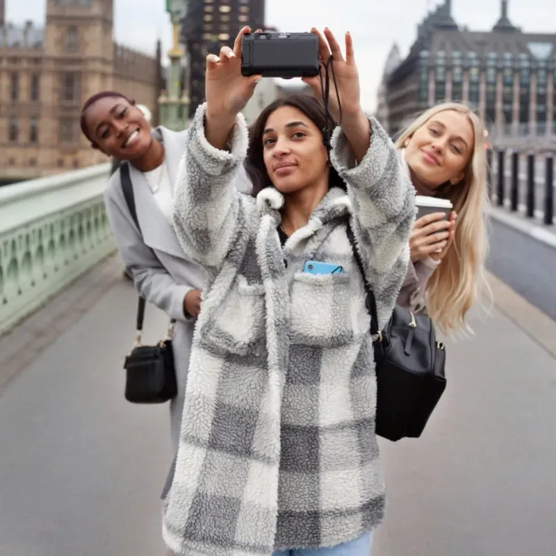 Three women are taking a selfie on a bridge