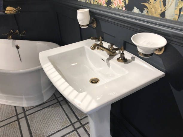 A bathroom with a pedestal sink and a bathtub