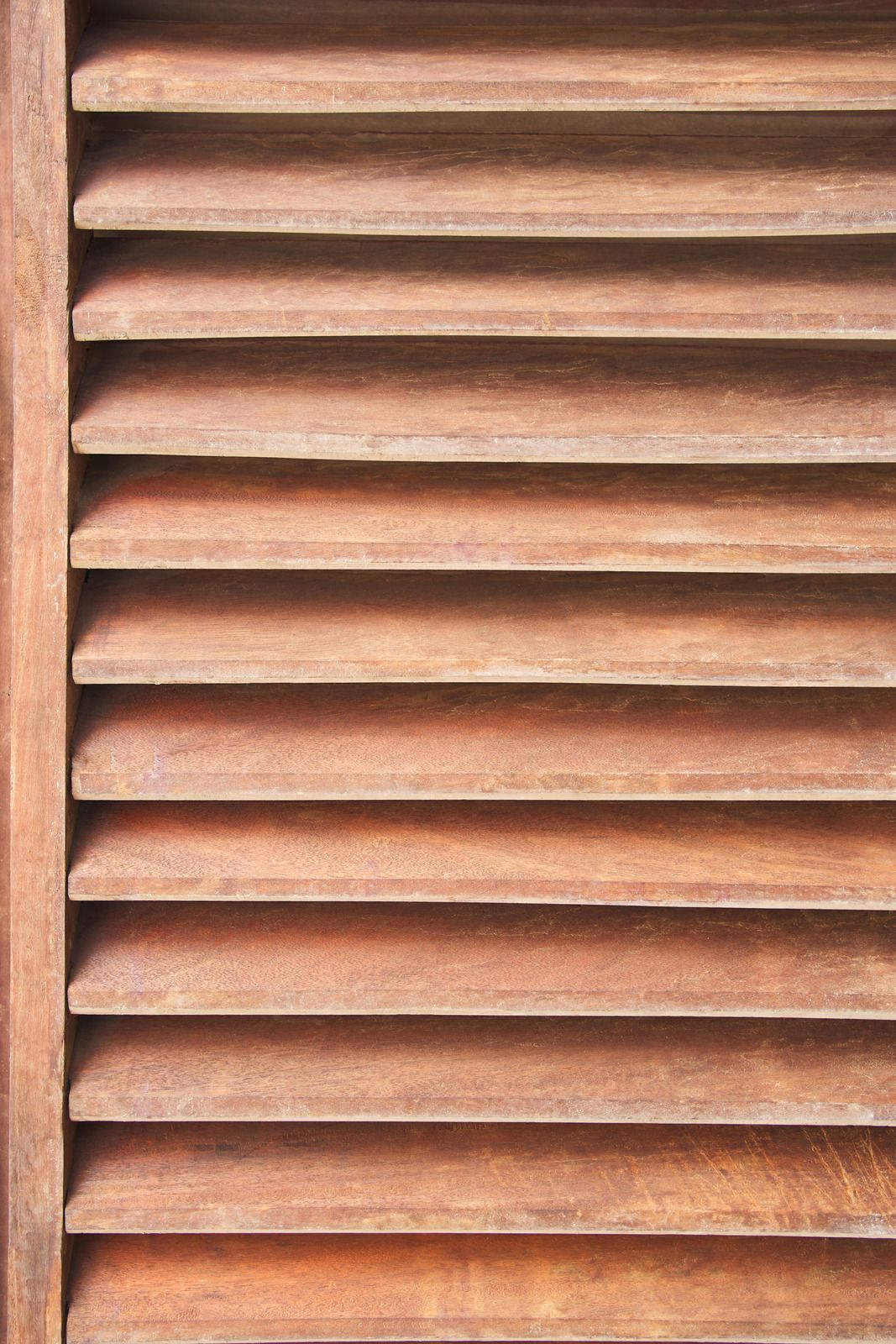 Wooden window shutters, close-up, horizontal slats in warm brown tones.