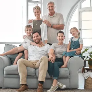 A family is posing for a picture while sitting on a couch.