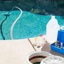 Poolside scene: Pool with equipment, chemicals, and water testing supplies.