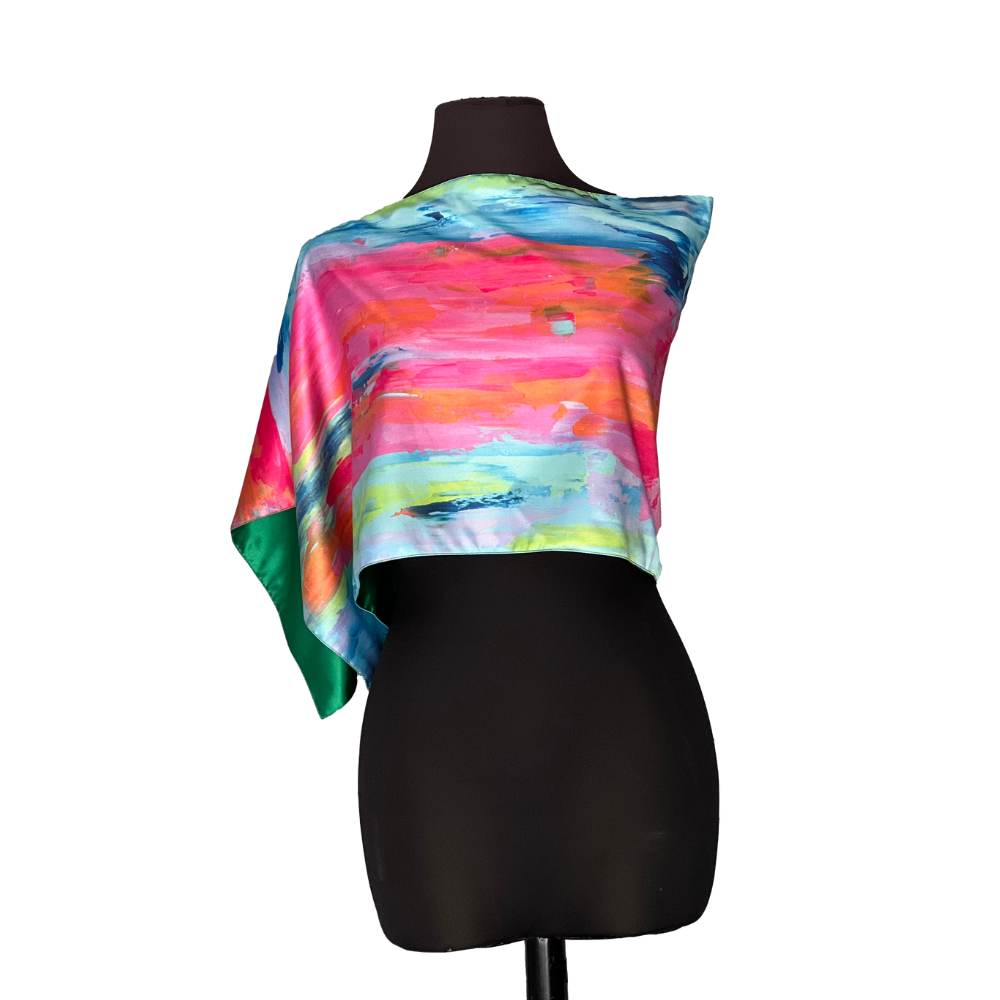 Colorful silk scarf on a black mannequin, displaying pink, blue, and green abstract art.
