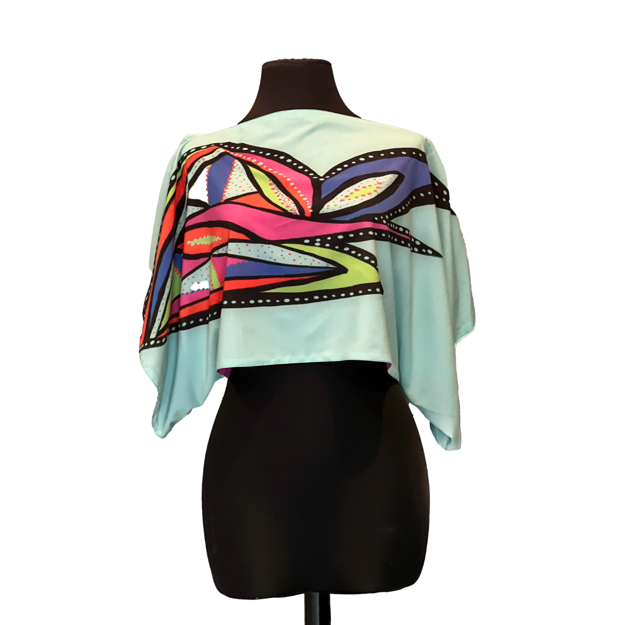 Light blue cropped poncho with a colorful abstract design on a black mannequin.