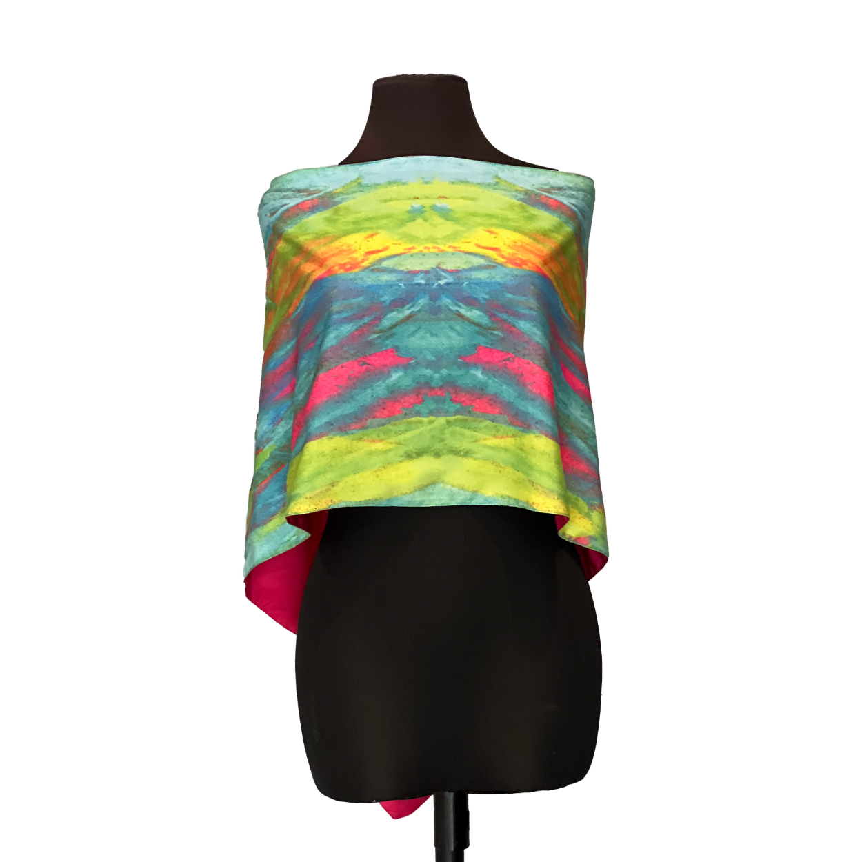 Colorful tie-dye silk scarf draped over a black mannequin, with shades of green, blue, pink, and yellow.