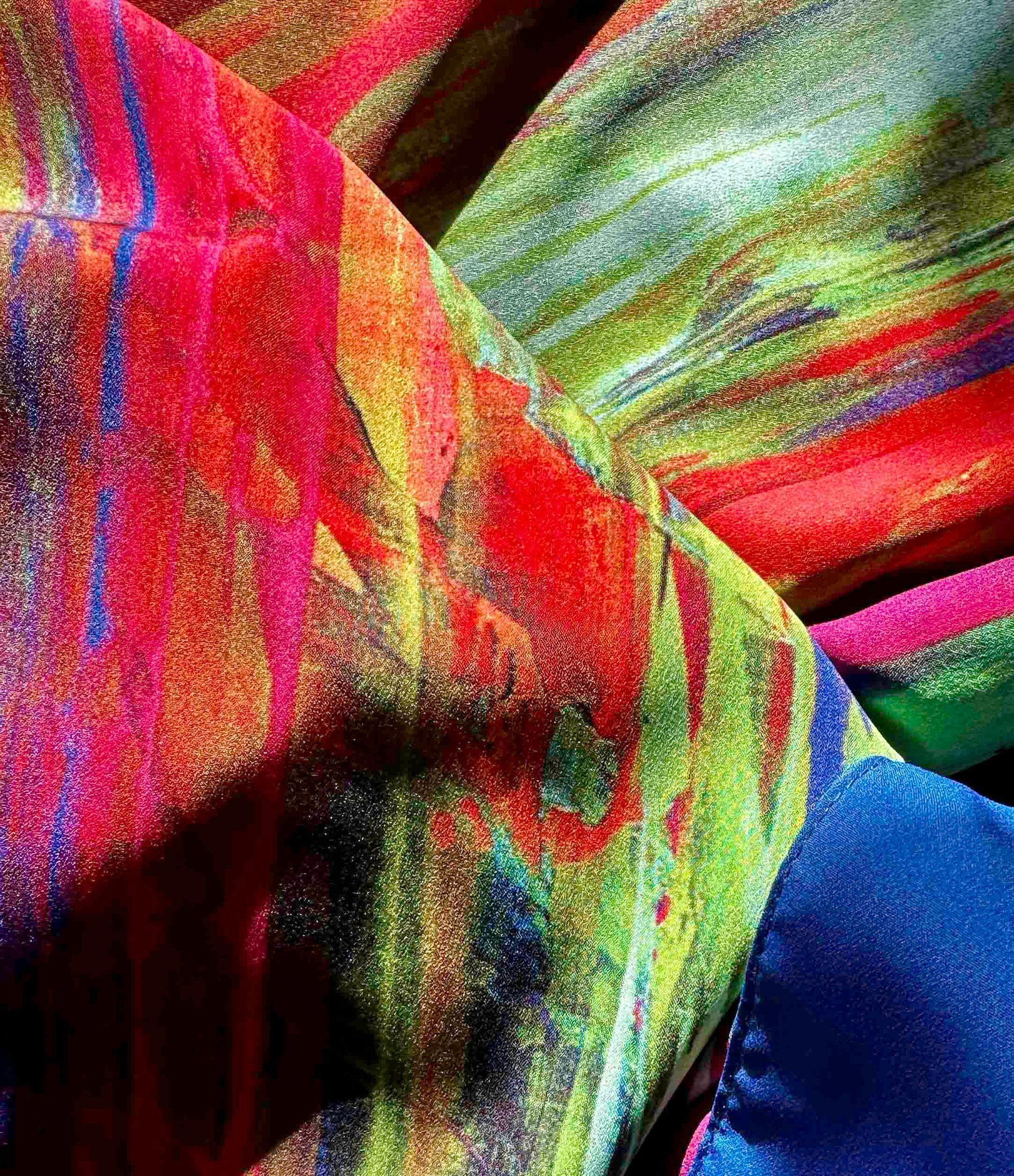Close-up of vibrant, colorful fabric with red, yellow, green, and blue hues.