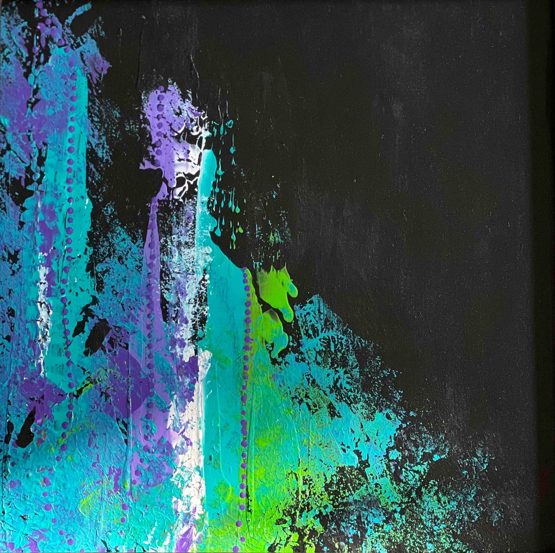 Black shawl with blue and green abstract design draped on a mannequin.