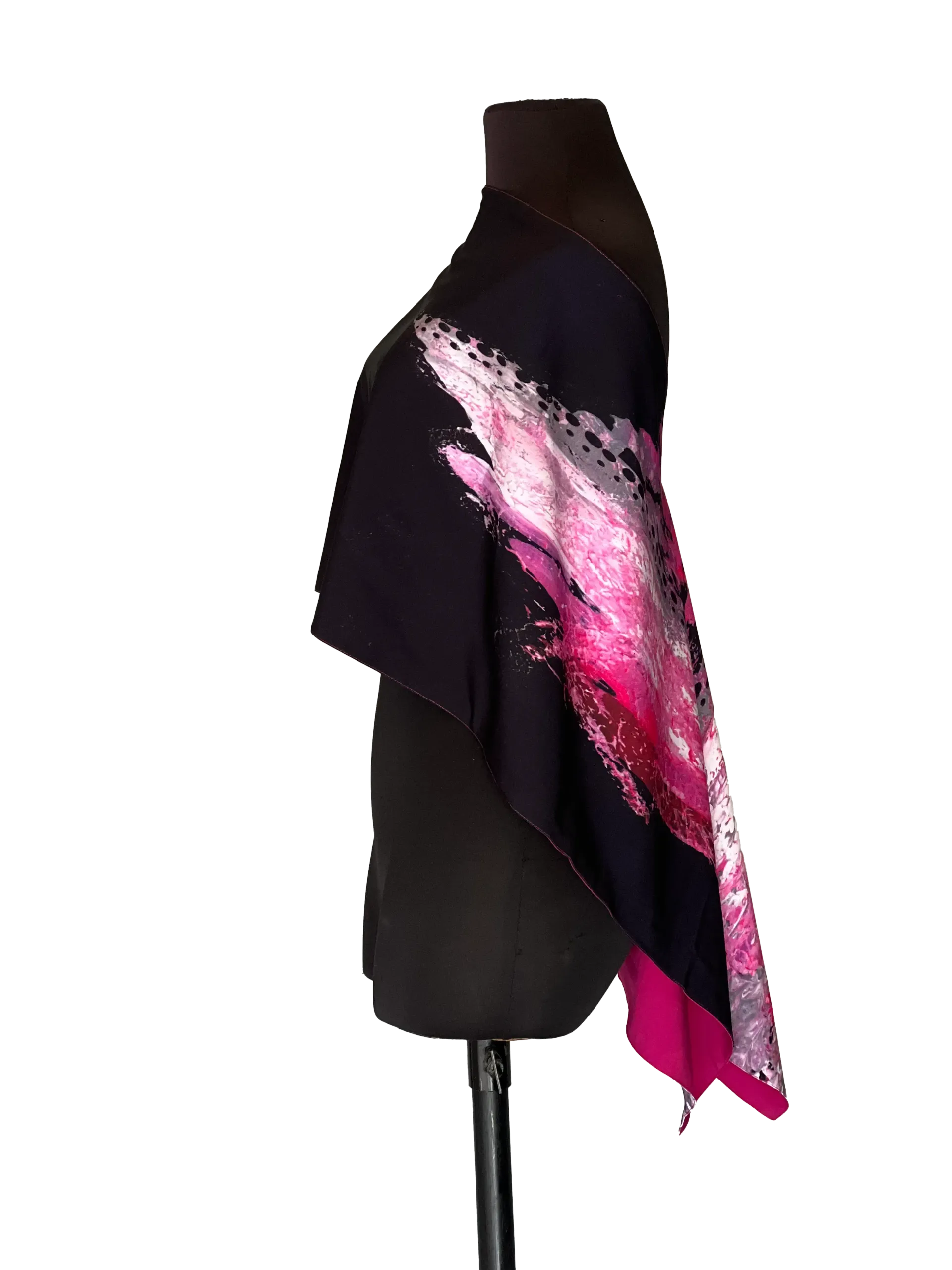 Black cape with pink feather design on a mannequin.