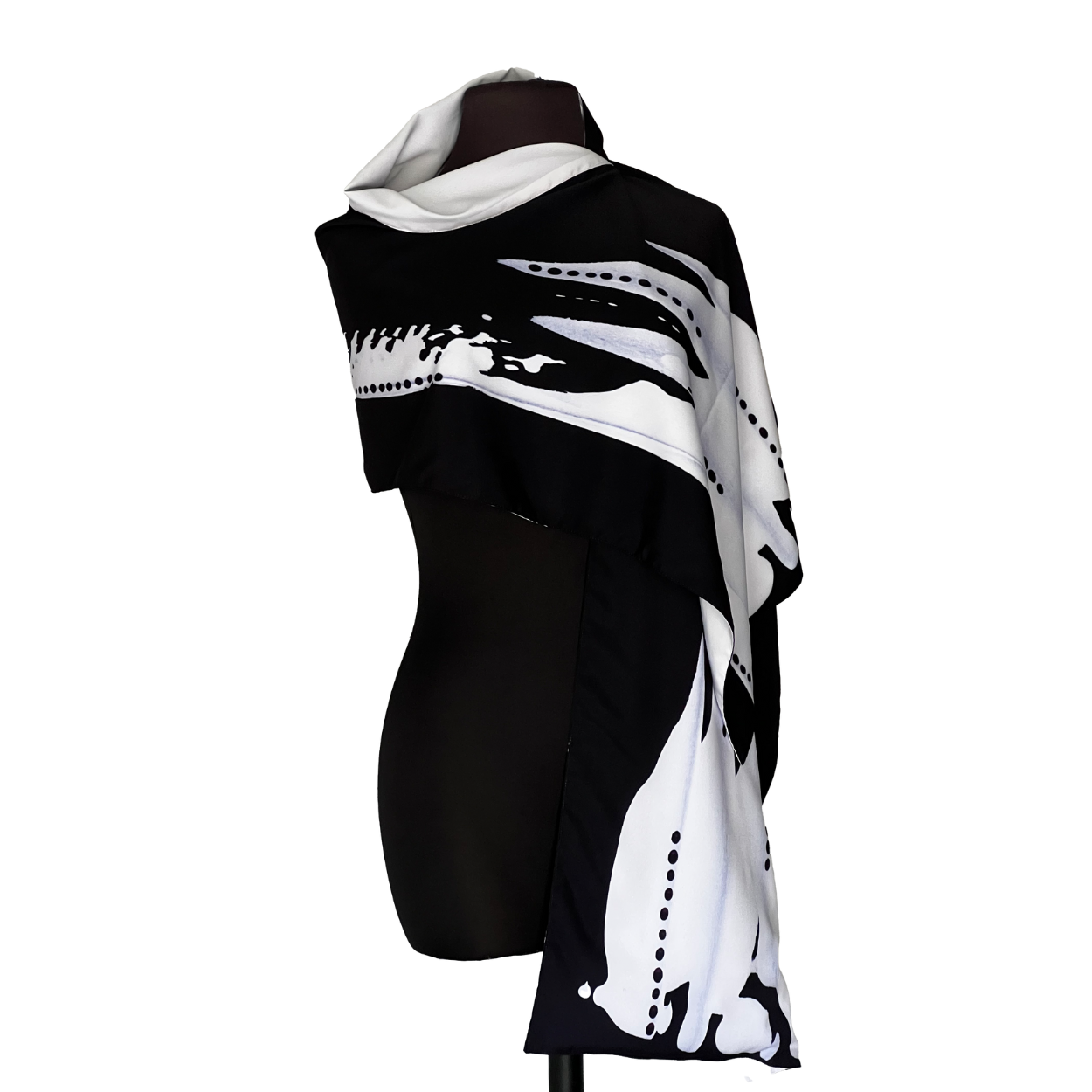 Black and white patterned scarf draped on a black mannequin.