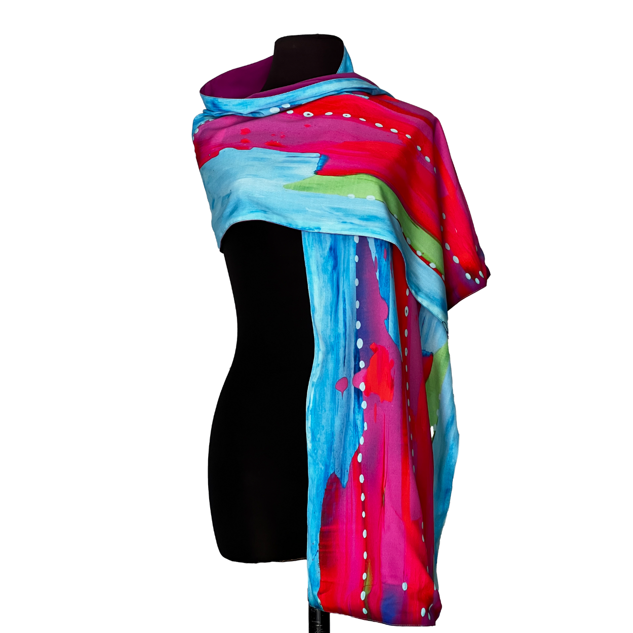 Colorful silk scarf draped on a black mannequin, with abstract brushstroke design in blues, pinks, and reds.