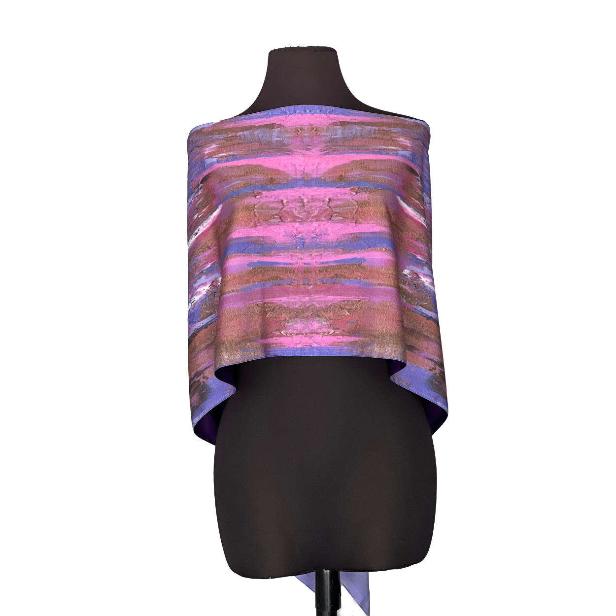 Pink, purple, and brown patterned poncho on a black mannequin.