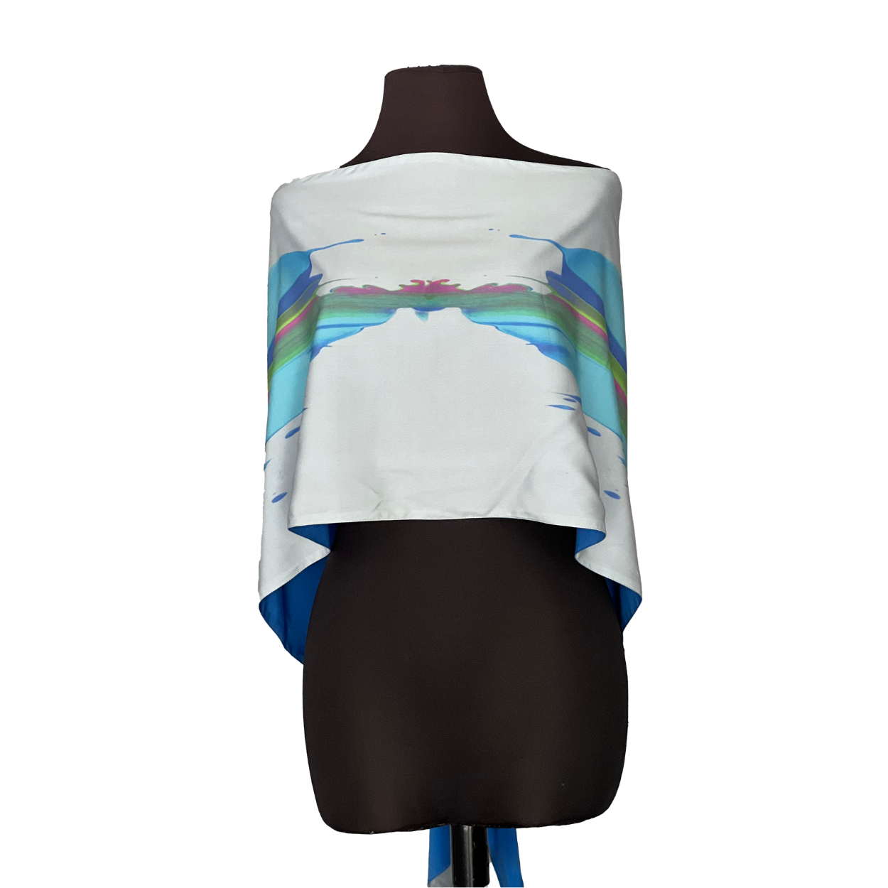 White poncho on a black mannequin, with a blue and colorful abstract design.