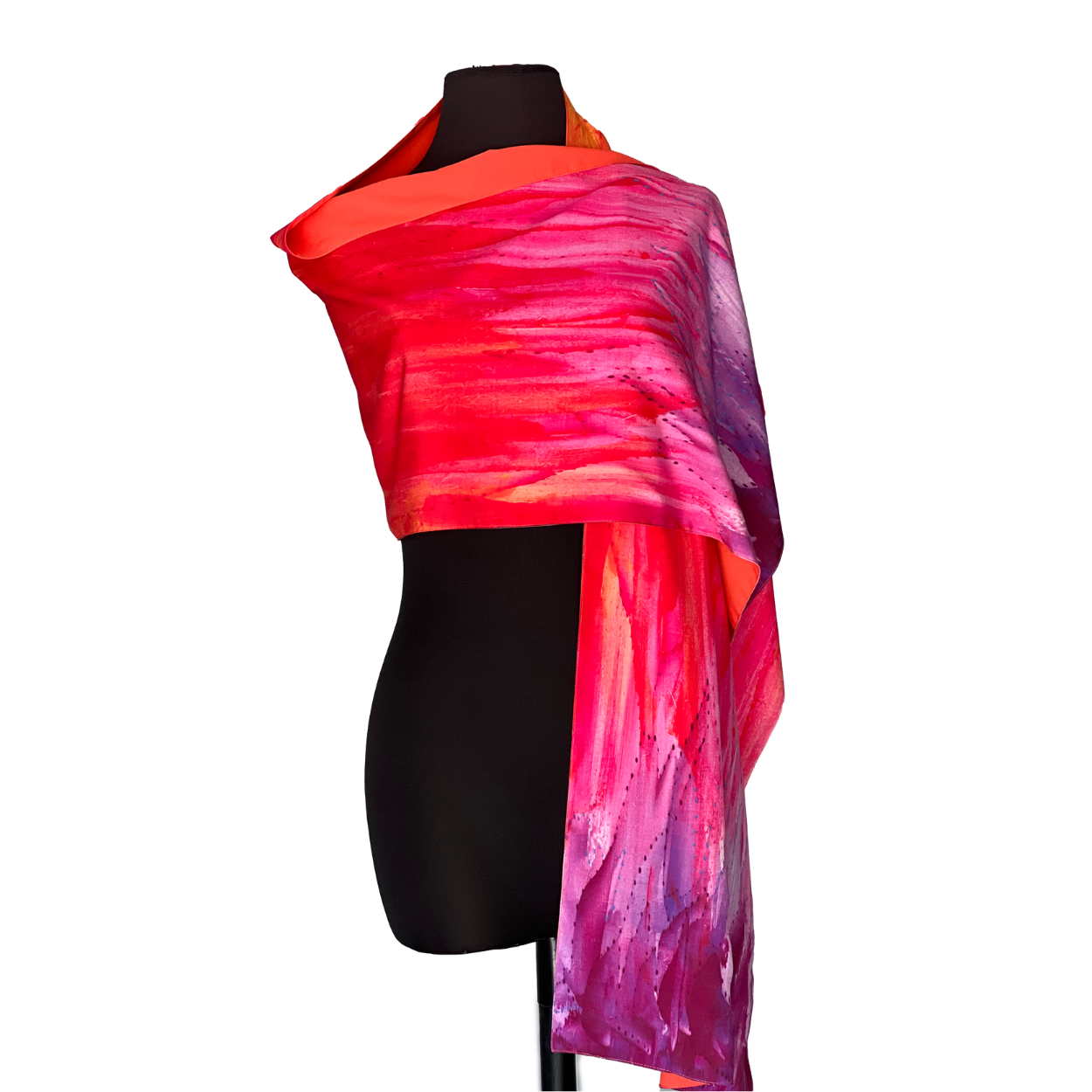 Bright red and purple silk scarf draped on a black mannequin, with a painted, abstract design.