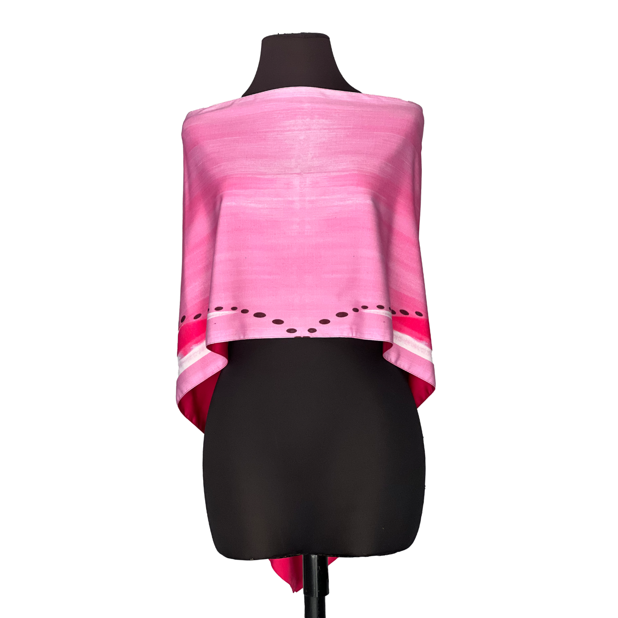 Pink silk poncho on a black mannequin, with decorative stripes along the bottom edge.