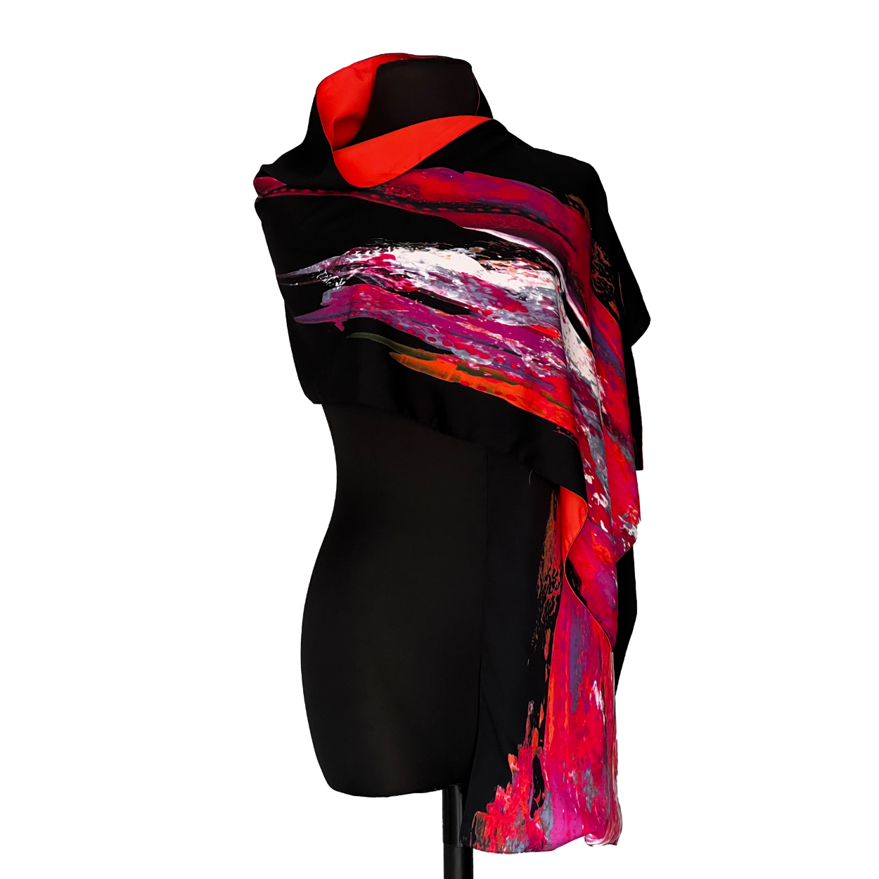 Black mannequin wearing a scarf with a colorful abstract design in shades of red, pink, and white.