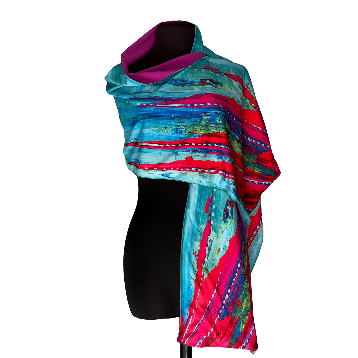 Abstract art scarf on black mannequin, teal, pink, and red hues.