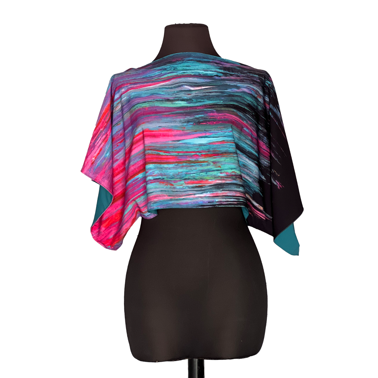 Abstract-patterned, short-sleeved top draped on a black mannequin. Colors include teal, pink, purple, and black.