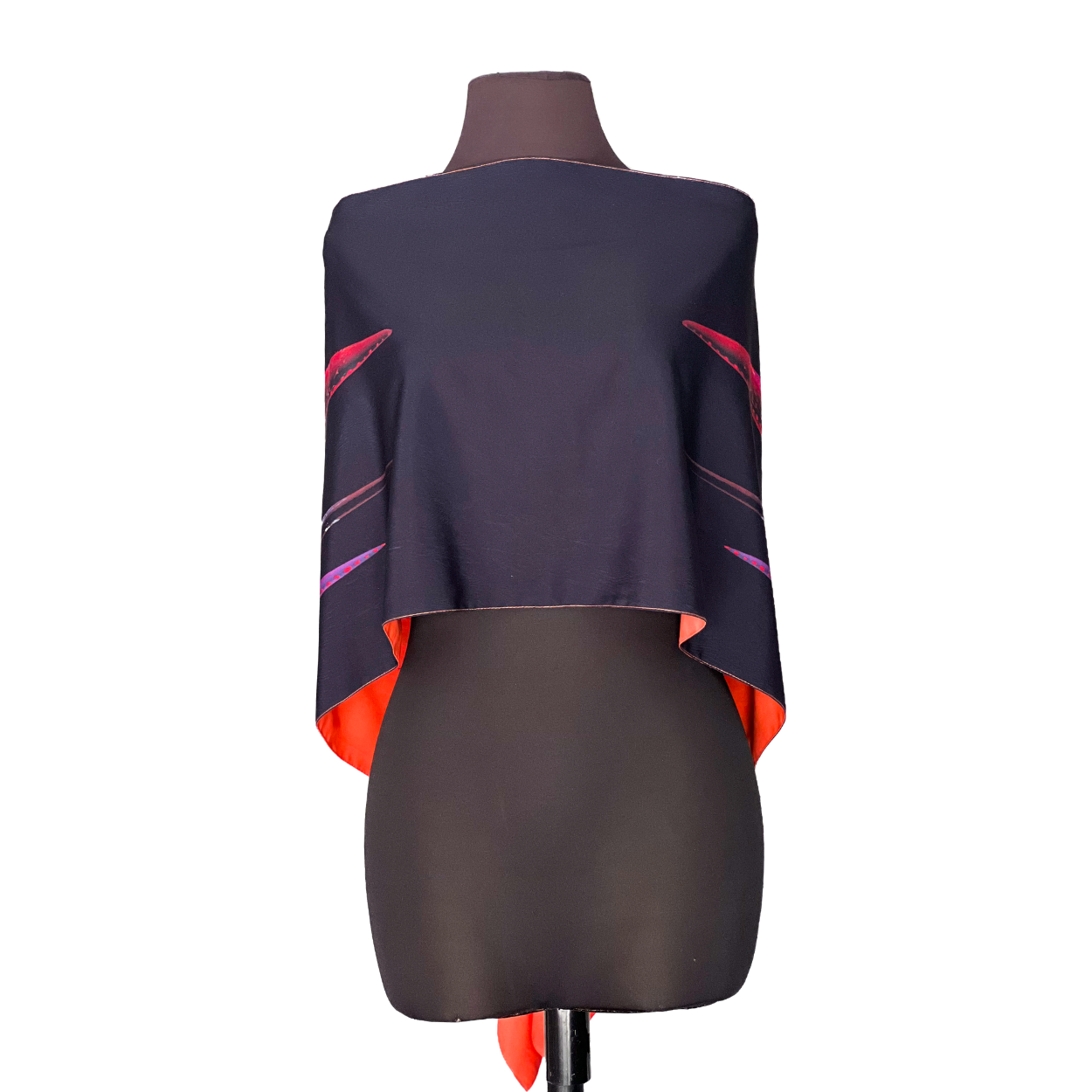Dark poncho with orange lining and pink/red accent lines displayed on a mannequin.