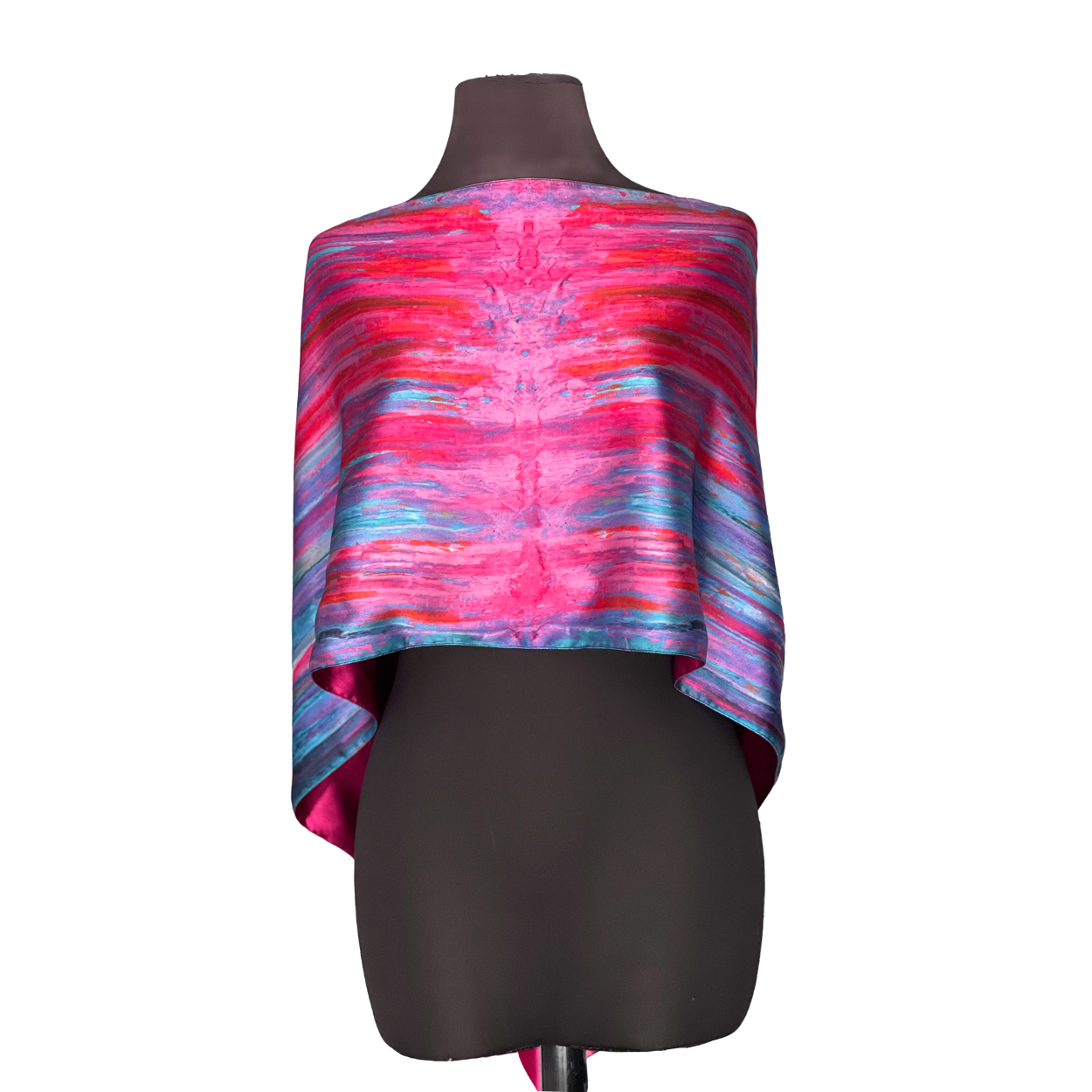 Silk poncho with pink, blue, and purple abstract pattern displayed on a mannequin.